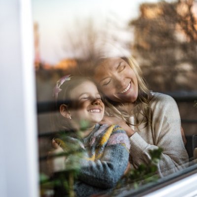 Mutter und Tochter am Fenster genießen ruhige Auszeit