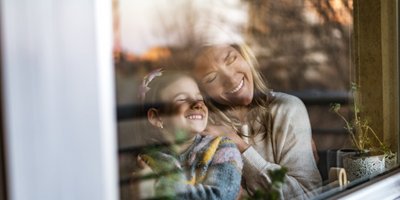 Mutter und Tochter am Fenster genießen ruhige Auszeit